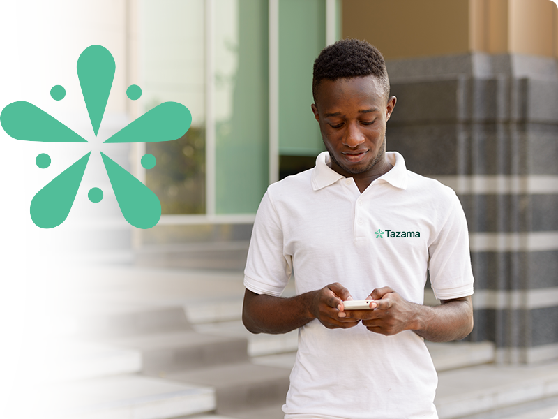 Man looking at mobile device with Tazama shirt on